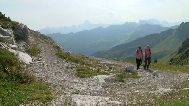 图为一对登山夫妇在德国巴伐利亚州内伯霍恩山(Mount Nebelhorn)登山时的照片视频素材