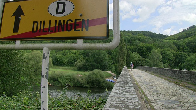 MS Shot of Cyclist at old Sauer Bridge / Dillingen, Echternach，卢森堡视频素材