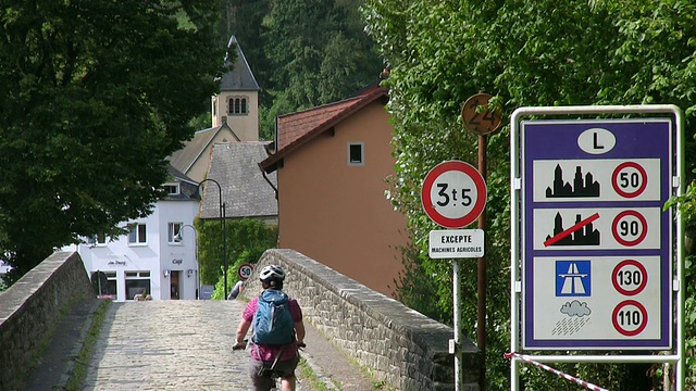 MS Shot of Cyclist at old Sauer Bridge / Dillingen, Echternach，卢森堡视频素材