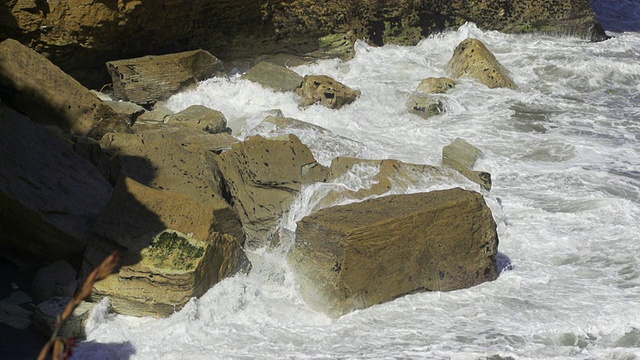 慢镜头:海浪拍打着岩石视频素材