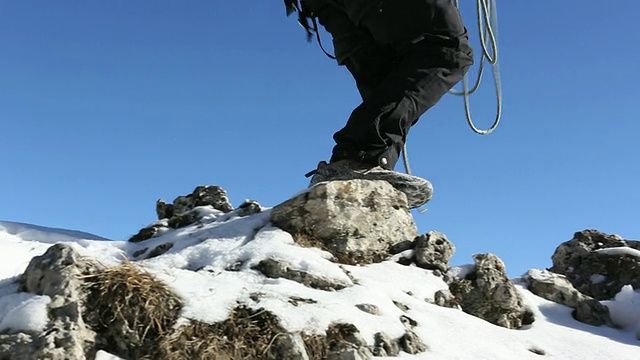 父子俩翻越白雪皑皑的山脊，后面的山峦视频素材