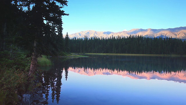 夕阳下的高山在高山湖上反射着他们的光辉视频素材