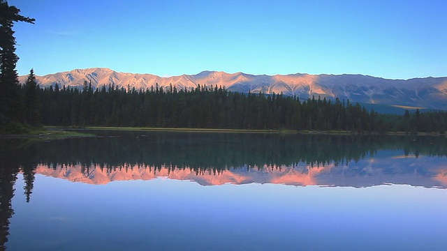 夕阳下的高山在高山湖上反射着他们的光辉视频素材