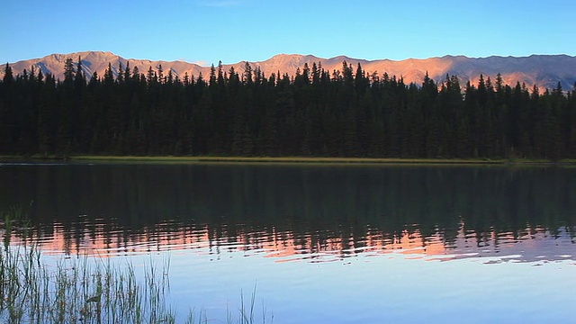 夕阳下的高山在高山湖上反射着他们的光辉视频素材