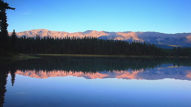 夕阳下的高山在高山湖上反射着他们的光辉视频素材