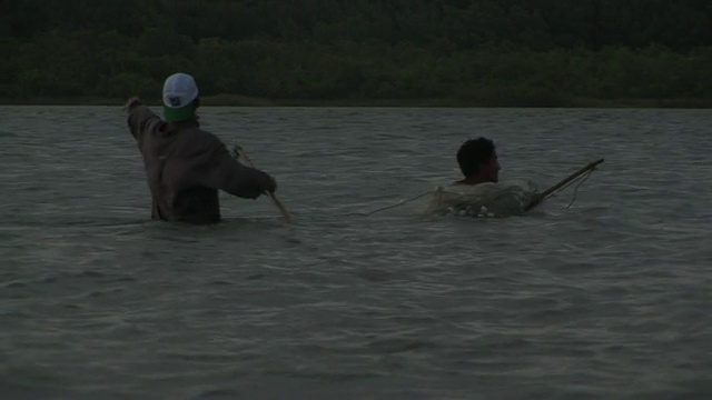 日落时分，两名男子在用网捕鱼/ Ilha dos Lencois, Maranhao，巴西视频素材