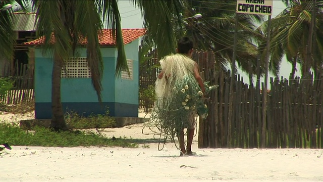 MS Boy带着渔网行走/ Ilha dos Lencois, Maranhao，巴西视频素材