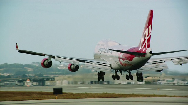 维珍航空747大型喷气式飞机在接近着陆时条纹进入框架，然后在SFO机场的跑道上着陆视频素材