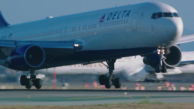 达美航空(delta Airlines)的大型喷气式客机以慢镜头着陆，摄像机跟踪着起落架视频素材