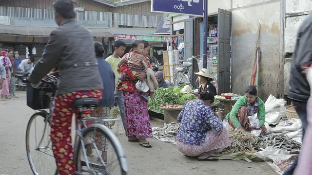 缅甸蒲甘市场，男男女女在购物，头上顶着货物视频素材