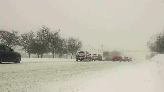 冬天的暴风雪。在湿滑的道路上车辆来往。视频素材