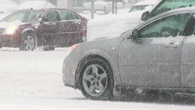 冬天的暴风雪。在湿滑的道路上车辆来往。视频素材