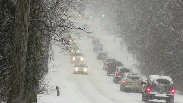 冬天的暴风雪。在湿滑的道路上车辆来往。视频下载