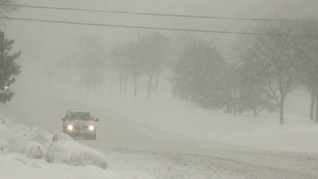 冬天的暴风雪。在湿滑的道路上车辆来往。视频素材