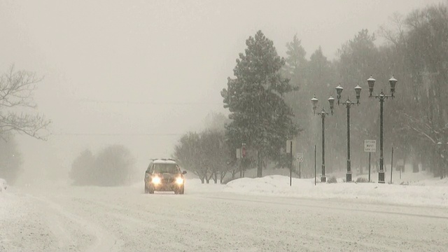 冬天的暴风雪。在湿滑的道路上车辆来往。视频素材