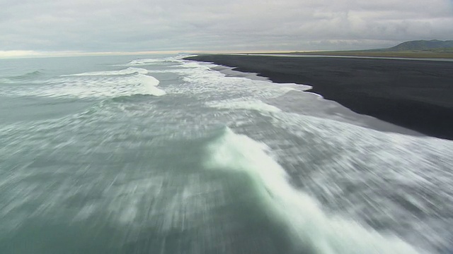 WS AERIAL POV海浪撞击在Skeidersandur海岸/冰岛视频素材