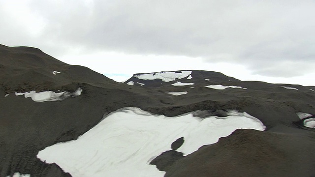 WS鸟瞰图雪熔岩平原对山/冰岛视频素材