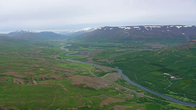 在冰岛Akureyri镇的山上有雪的农田山谷的WS鸟瞰图视频素材