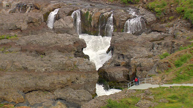 冰岛Hraunfossar和Barnafoss瀑布下流淌着岩浆的一对夫妇的鸟瞰图视频素材