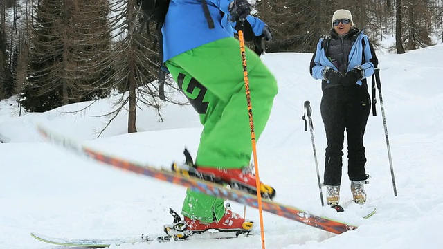 滑雪者顽皮地把雪踢到同伴身上视频素材