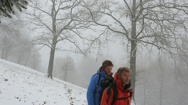 把焦点放在父子徒步旅行/在暴风雪中使用指南针视频素材