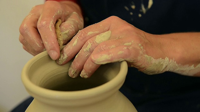 在德国巴伐利亚州的pottery / Landshut，女陶工在陶轮上完成陶罐成型视频素材