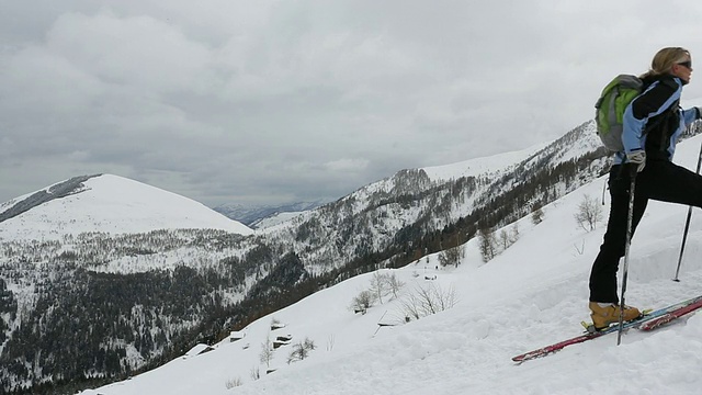 滑雪者爬上陡峭的雪坡，雪山很远视频素材