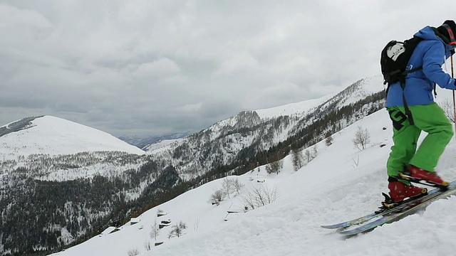 滑雪者爬上陡峭的雪坡，雪山很远视频素材