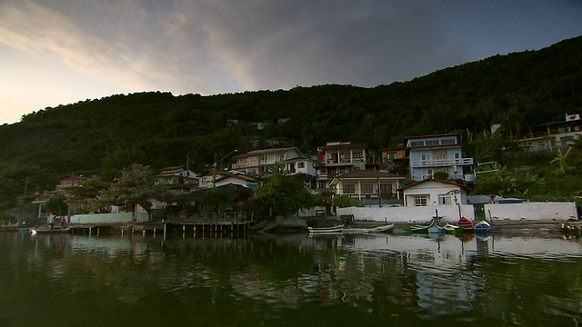 建在山上的水边住宅，前面有小船，日落，巴西Florianopolis郊区[FlorianÃ³polis][巴西]视频素材