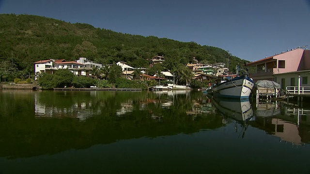 沿着非常静止的水道向巴西Florianopolis郊区山丘上建的河边住宅[FlorianÃ³polis]移动[巴西]视频素材