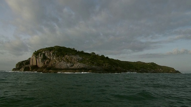 巴西Florianopolis [FlorianÃ³polis]海岸外的Ilna do Xavier岛[巴西]，波涛汹涌的海面，静止的船视频素材