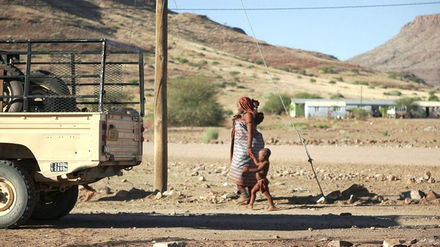 MS土著妇女和孩子走在乡村街道上/ Bergsig, Kunene，纳米比亚视频素材