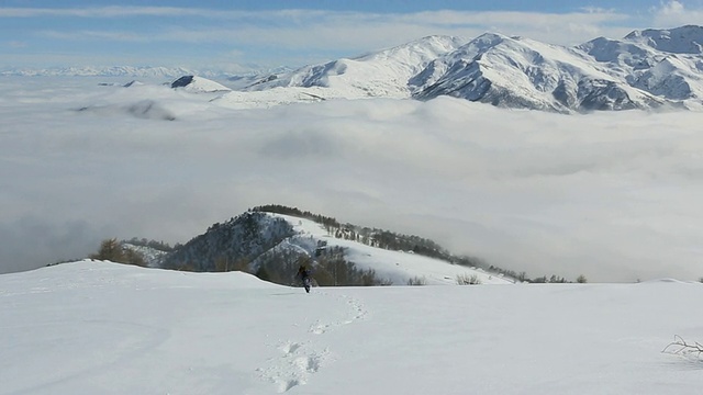 一个徒步旅行者沿着雪山边跑向山谷迷雾视频素材