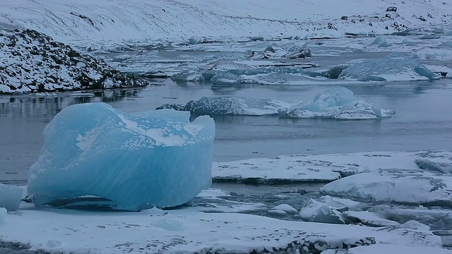 这是早晨Jokulsarlon泻湖上漂浮的冰川，野生水鸟正在通过泻湖/冰岛视频素材