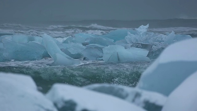 在冰岛Jokulsarlon河口的Jokulsa冰山海滩上，海浪滚滚而来视频素材