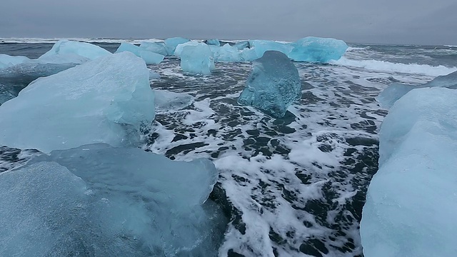 在冰岛Jokulsarlon河口的Jokulsa冰山海滩上，海浪翻滚着冲刷冰川视频素材