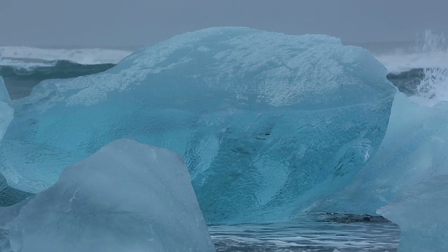 在冰岛Jokulsarlon河口的Jokulsa冰山海滩上，海浪翻滚着冲刷冰川视频素材