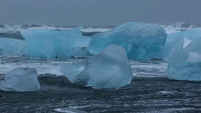 在冰岛Jokulsarlon河口的Jokulsa冰山海滩上，海浪翻滚着冲刷冰川视频素材