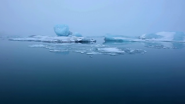 清晨Jokulsarlon泻湖的漂流和移动的冰川，冰川反映在水面/冰岛视频素材