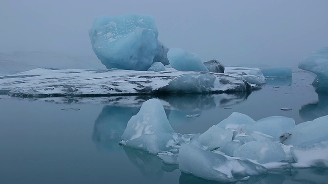 巨大的冰川漂浮在平静的Jokulsarlon泻湖表面，冰川反射在水面/冰岛视频素材