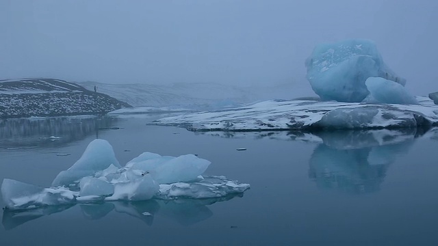 巨大的冰川漂浮在平静的Jokulsarlon泻湖表面，冰川反射在水面/冰岛视频素材