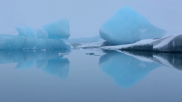 冰川的碎片漂浮和漂移在平静的Jokulsarlon泻湖表面，冰川反射在水面/冰岛视频素材