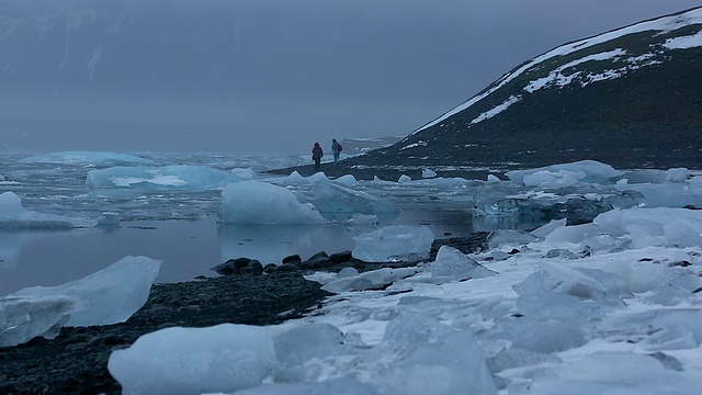 冰岛Jokulsarlon泻湖的水面上，人们在湖边行走，冰川反射和漂浮视频素材