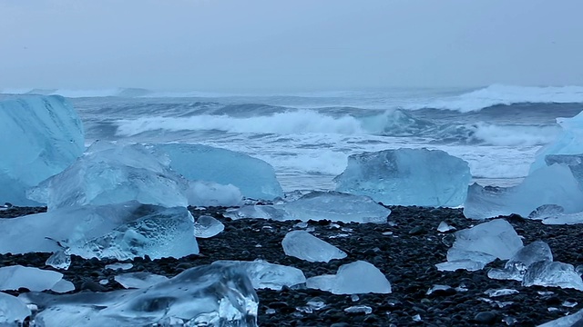 黎明时分，冰岛Jokulsa冰山滩上被冲刷的冰川和Jokulsarlon口的雪山和海洋视频素材