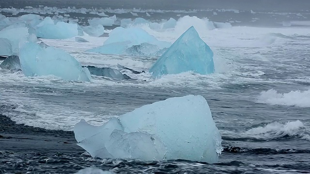 在冰岛Jokulsarlon河口的Jokulsa冰山海滩上，海浪翻滚着冲刷冰川视频素材