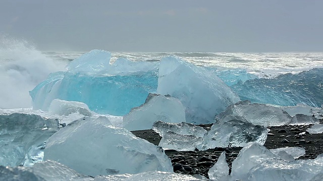 在冰岛Jokulsarlon河口的Jokulsa冰山海滩上，海浪翻滚着冲刷冰川视频素材