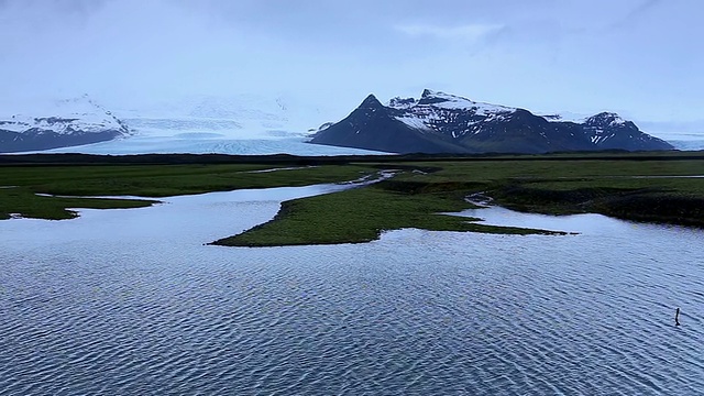 Fjallsjokull冰川和起伏的泻湖与雪山/冰岛全景图视频素材