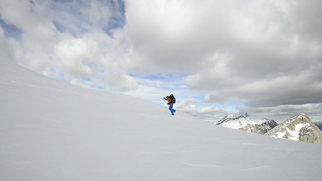 登山者攀登雪坡，越过群山视频素材