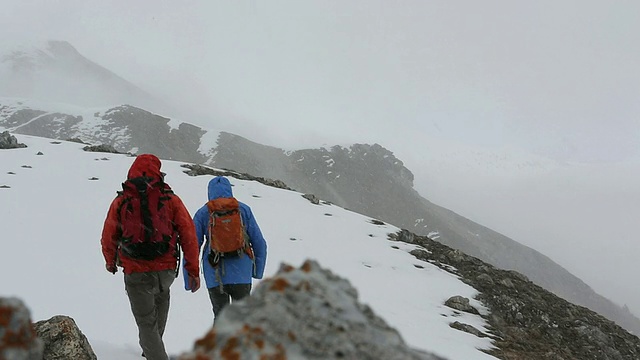 徒步旅行者在暴风雪中穿越多雪地带视频素材