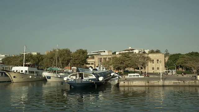 当你航行到罗德岛的时候，海港，船只和建筑物的日景。沿着水面移动射击。旅游目的地视频素材